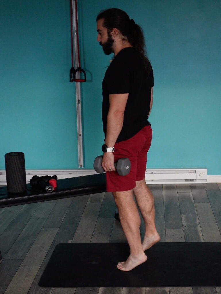 Dr. John standing with his heels lifted preparing to do a negative calf raise for achilles tendinitis self-care